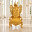 An ornate golden throne chair with a tufted backrest, crown on the back, and carved arms, set in a bright, elegant room with marble floors and tall windows.