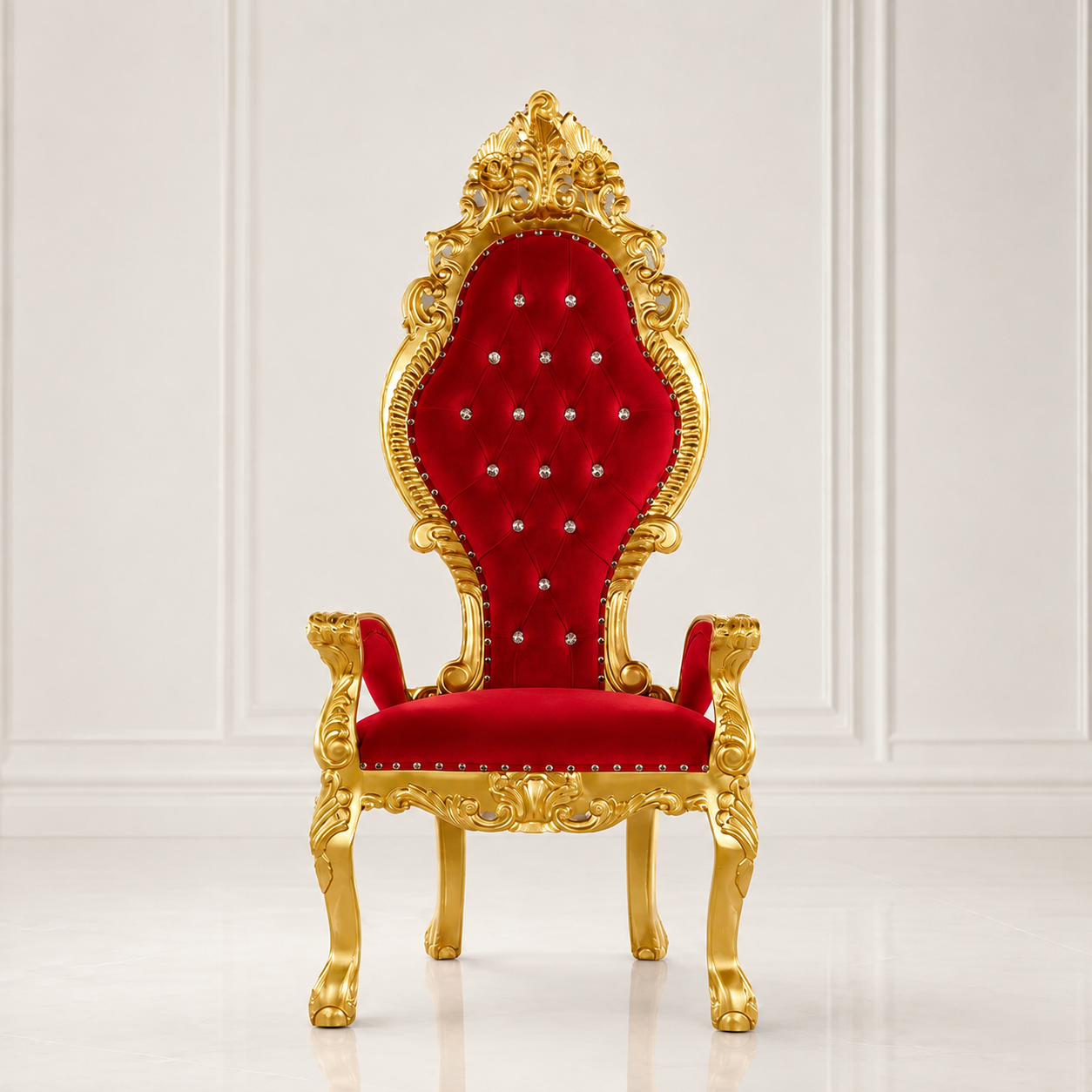 An ornate high-back throne chair with a carved gold frame and deep red velvet upholstery, set against a white paneled wall background.