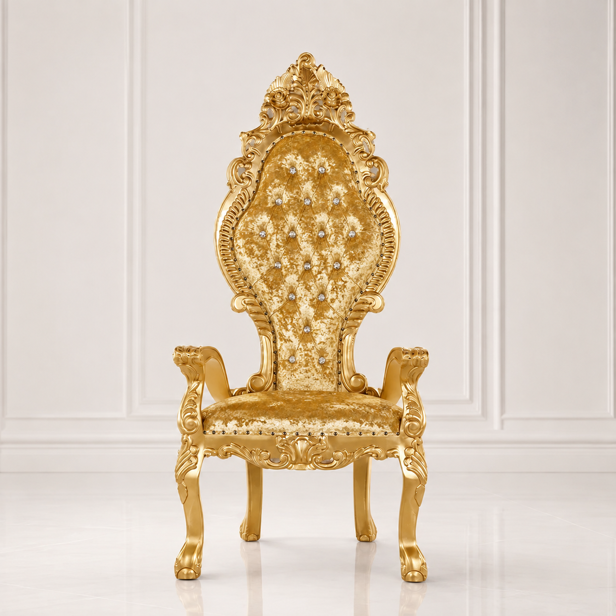 An ornate gold throne chair with a high tufted backrest, carved details, and jeweled embellishments, set against a white paneled wall background.